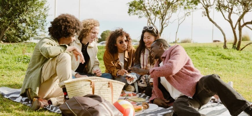 A,Group,Of,Four,Friends,Sit,And,Laugh,While,Listening